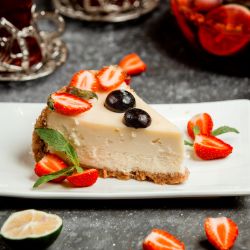 classic cheesecake with strawberry and cherry slices