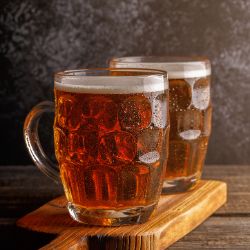 Beer. Cold beer in glass with chips on a dark background.